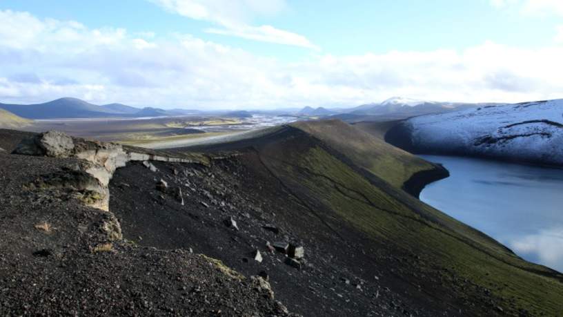 De Ljotipollur krater. Water, felgroen mos en zwarte lavavelden